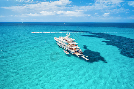 巴利阿里群岛蔚蓝海岸上的游艇夏天阳光明媚的日子里,人们透明的海洋中观看浮船的鸟瞰图无人机的顶部视图海景与豪华游艇图片