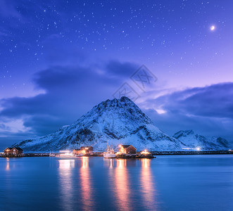 渔船靠近码头的海上雪山星空紫色的天空与月亮卢福滕群岛,挪威冬季景观与船舶,建筑物,照明,岩石云图片