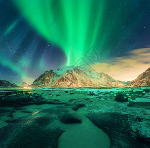 雪山上的极光挪威洛福滕岛的北极光极地灯光的星空夜间冬季景观与绿色北极光,石头,沙滩,岩石,照明图片