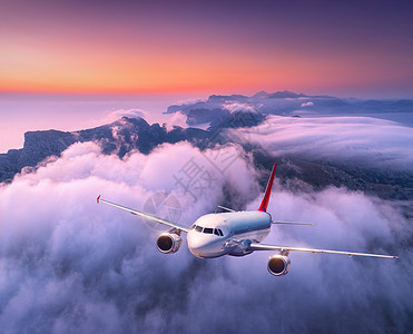 日落时乘飞机飞越云层风景与大白飞机,低云,海,紫色的天空黄昏飞机正降落出差商业飞机旅行空中视野图片