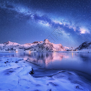 挪威洛福腾群岛的冬天,冰封的海岸上的银河雪覆盖着山脉北极景观蓝色的星空,水,冰,雪岩,银河美丽的背景图片