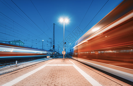 两列高速列车火车站夜间行驶欧洲的铁路站台上移动模糊的现代城际列车客运铁路运输黄昏时的铁路旅行图片