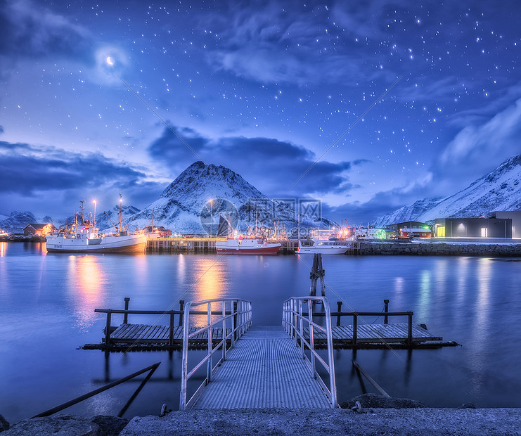 渔船靠近码头的海上雪山星空与月亮卢福滕群岛,挪威冬季景观与桥梁,船舶,建筑,照明,岩石云图片