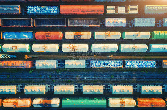 日落时货运列车的鸟瞰图铁路货车,铁路上货物火车站上五颜六色的货运火车的顶景重工业工业景观运输图片