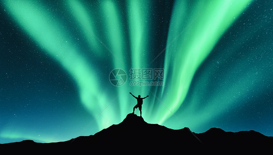 挪威的山上,北极光站立的人的山上北极光快乐的人天空中星星绿色的北极光夜间景观与极光图片