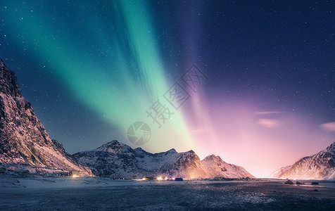 雪山上绿色紫色的北极光挪威洛福滕岛的北极光极地灯光的星空夜间冬季景观与极光,高岩石,海滩旅行风景背景图片