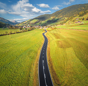 意大利白云石山谷道路的鸟瞰图完美的沥青道路的顶部景观,绿草草地,秋天的村庄公路穿过田野欧洲旅行旅行图片