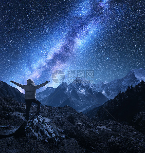 个站立的人的轮廓,举手臂石头,山脉星空与银河夜间尼泊尔明亮的星星旅行山岭星系的景观图片