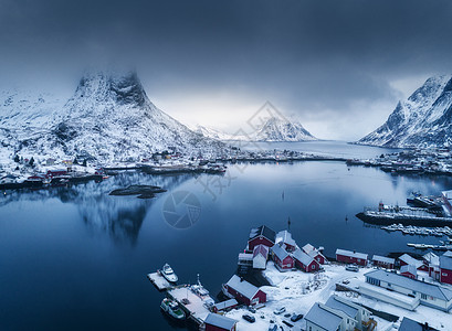 挪威洛福腾群岛冬季阴天雷恩的空中景观忧郁的景观与蓝色的海洋,雪山低云,岩石,村庄,建筑物,罗布,多云的天空的风景图片