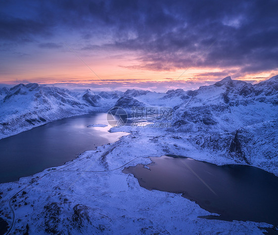 挪威洛福腾岛的雪山海洋彩色多云天空的空中景色冬季景观雪覆盖的岩石海岸日落的天空黄昏时挪威峡湾的顶部景色图片