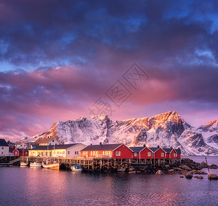 哈姆诺伊美丽的渔村,日出时船,洛芬岛,挪威冬天的风景房子,雪山,大海,船,五颜六色的天空云挪威传统的红色Rorbu岩石背景