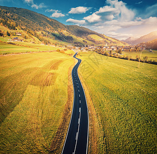 意大利白云石的山谷日落时的道路鸟瞰图完美的沥青道路的顶部景观,绿草草地,秋天的村庄公路穿过田野欧洲旅行图片