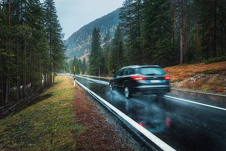 模糊的汽车秋天的森林里的道路上运动阴雨天完美的沥青山路巷道,意大利阿尔卑斯山的松树运输雾林中的公路旅行图片