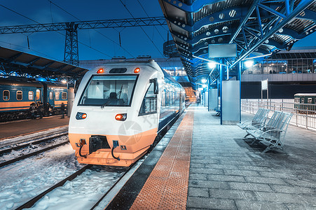 冬天晚上火车站的高速列车城市景观与现代通勤列车铁路站台与照明黄昏城际车辆乘客铁路旅行图片