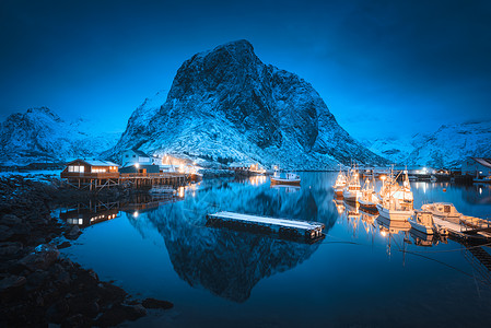 渔村,晚上船海上雪山洛福滕岛,挪威冬季景观与房屋,码头,照明,岩石,喜怒无常的天空反射水中挪威罗布图片