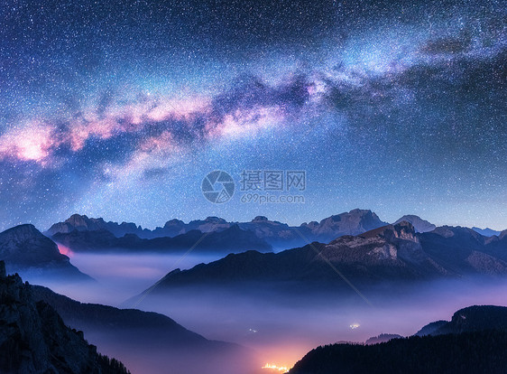 秋天的夜晚,雾中的银河山上景观与高山山谷,低云,紫色星空与银河,城市照明空中飞行帕索Giau,白云石,意大利图片