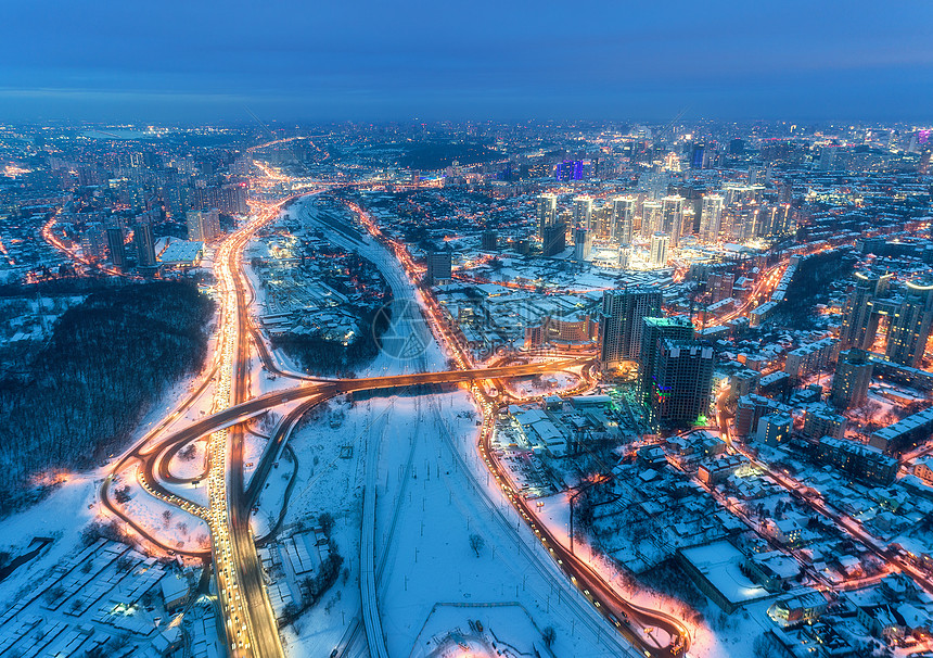 冬季寒冷夜晚美丽的现代城市的鸟瞰图道路建筑物雪街道上的交通景观天际线远离无人机的城市景观市中心高速公路的鸟瞰图片