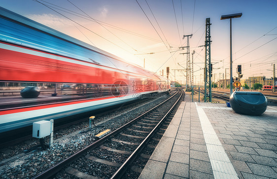 红色高速列车火车站上运动,五颜六色的日落模糊的现代城际列车,铁路站台的窗户上天空反射客运铁路图片