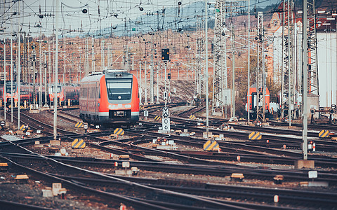 德国纽伦堡日落时配现代红色通勤火车的火车站带复古色调的铁路图片
