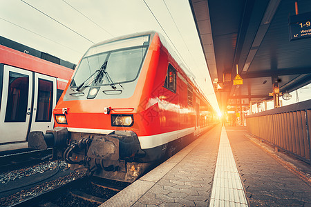 现代高速红色通勤列车五颜六色的日落美丽的火车站带复古色调的铁路火车铁路站台工业铁路旅游图片