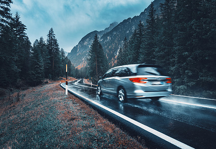 模糊的汽车秋天的森林里的道路上运动阴雨天完美的沥青山路巷道,意大利阿尔卑斯山的松树运输雾林中的公路旅行背景图片