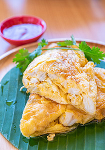 泰国煎蛋卷配螃蟹,煎蛋配蟹肉,泰国著名的街头食品木制餐桌上的餐厅菜肴背景图片