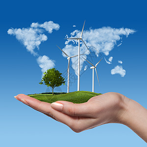 草地上树的风力涡轮机握着女人的手,抗蓝天由云成的世界全球绿色能源风力涡轮机,女手中树图片
