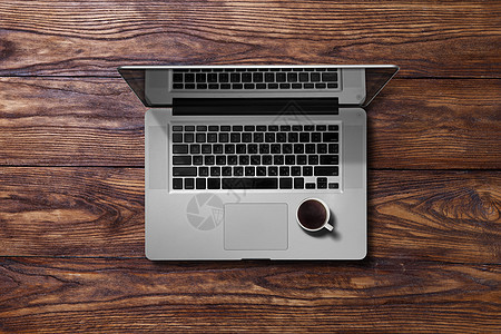 打开笔记本电脑杯咖啡打开笔记本电脑棕色木桌上的咖啡的风景图片