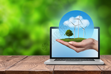 风车草地草地上树的风力涡轮机握着女人的手,着蓝天,木制桌子上的开放式笔记本电脑上云全球绿色能源风力涡轮机,女手中的背景