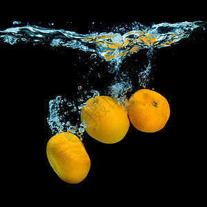 新鲜的橘子掉进水里,黑色上气泡图片