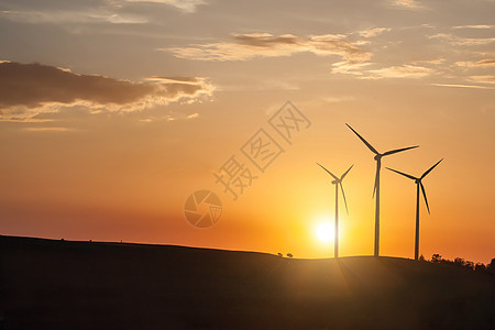日落时风力发电机涡轮机的照片图片