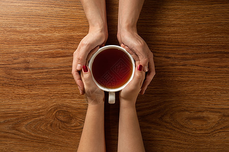 女人男人的手着热茶木桌上图片