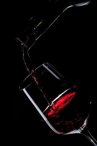 红酒倒入隔离黑色上的酒杯中