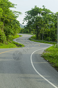 沥青道路尖锐的曲线与热带森林曲折前进图片