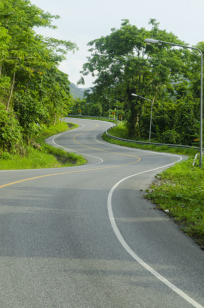 沥青道路尖锐的曲线与热带森林曲折前进图片