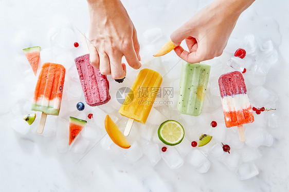 水果浆果冰棒冰块上个女人的手装饰冰淇淋与新鲜水果片平躺女人的手根棍子上装饰冰淇淋,些多汁的水果夏图片