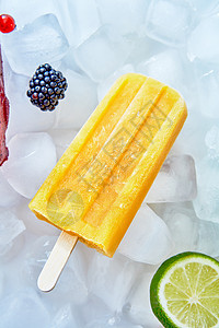 黄色柠檬冰糕与石灰浆果冰上,平躺夏日甜点排,健康的黄色冰棒冰棒与切片石灰浆果,平躺图片