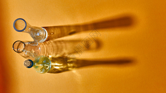 曲线花瓶眼镜空着,黄色背景上的表上阴影反射,放置文本研究实验室测试璃瓶科学医学背景黄色纸上三个璃空花瓶的顶部视背景