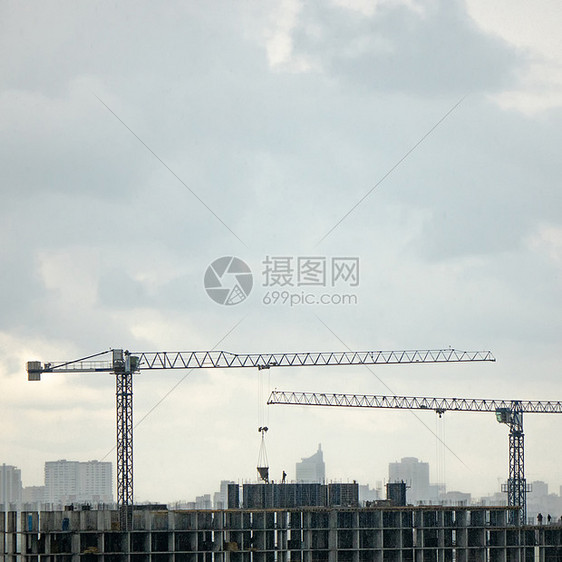 全景照片来自建建筑的无人机,两台塔式重机灰色多云的天空下建筑重机背景城市景观多云的天空下无人机的空中照片图片