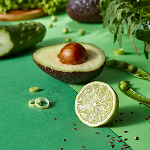 天然机绿色蔬菜,用于绿色背景下准备素食沙拉天然健康食品的文字的地方新鲜采摘的蔬菜沙拉鳄梨,焦点上的石灰,绿色图片