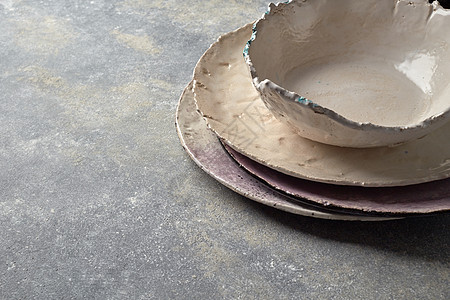 粘土手工空板,碗,覆盖灰色混凝土表上,文字平躺传统的纪念品瓷器手工制作的彩色盘子碗灰色的混凝土背景上图片