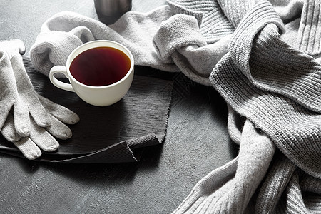 杯热咖啡张黑色桌子上,照片温暖的毛衣与杯子,冬天的早晨,顶部视图黑桌子上的杯热咖啡图片