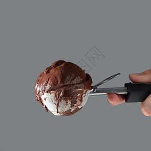 夏季与文本女手的特写灰色背景上的勺子里着美味的冷巧克力冰淇淋巧克力自制甜点金属勺子里放冰淇淋上,把女图片
