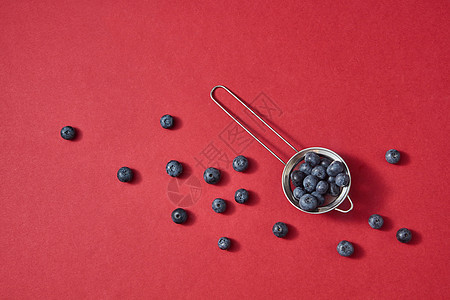 美味的甜天然浆果纸背景上,文字的地方清洁机饮食的平躺成熟的甜蓝莓个红色的纸背景红色上的天然啤酒花图图片