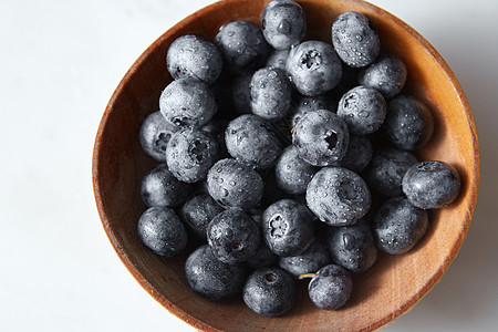 天然新鲜的国产水果特写美味浆果甜点厨房餐桌的配料成熟的甜蓝莓水滴中,灰色背景的木盘里的风景图片