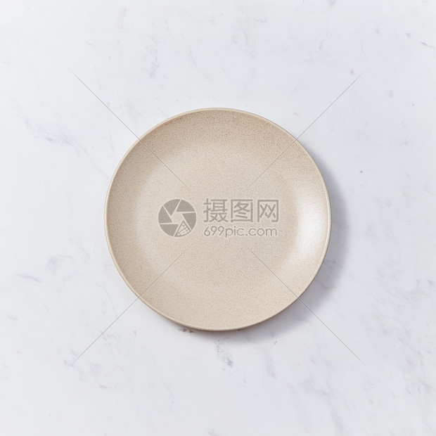 装饰粘土盘,覆盖灰色背景上的釉可用于蒙太奇您的产品手工陶瓷盘灰色大理石桌子上传统陶瓷手工制作图片