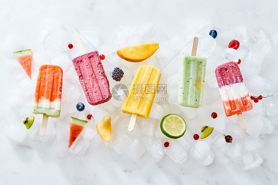 收集彩色明亮的天然冰淇淋冰棒与水果浆果冰块上自制健康冰棒平躺水果浆果与水果颜色的自制冰淇淋冰块上的棍子上图片
