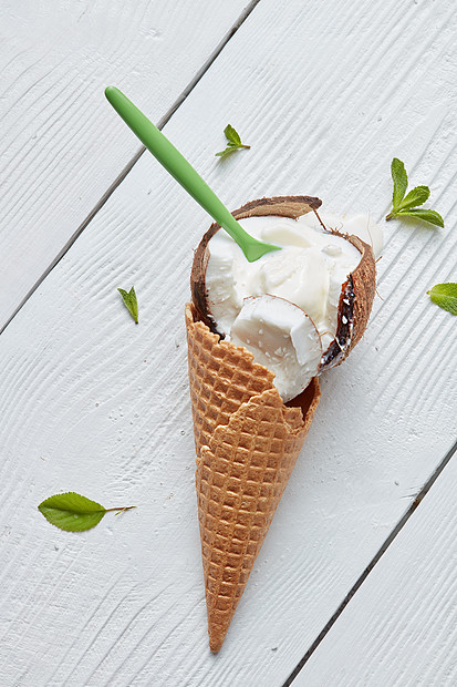 华夫饼锥与冰淇淋椰子与勺子薄荷叶白色木制背景平躺华夫饼锥冰淇淋图片