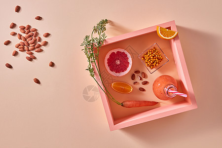 机饮料与沙棘,杏仁,柑橘类水果璃上的橙色纸方形框架健康的饮食食物平躺自制的天然机冰沙,用葡萄柚橘子浆果图片
