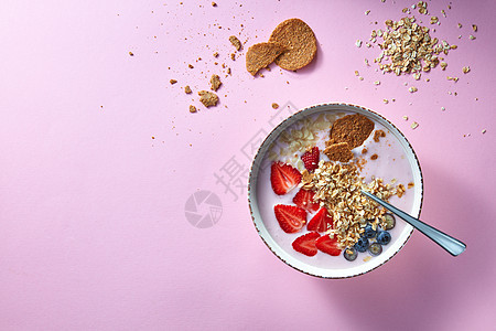 健康的冰沙白色碗与天然水果,燕麦片饼干的粉红色背景超级食物,自然排,饮食健康食品的风景碗白色的机酸奶图片